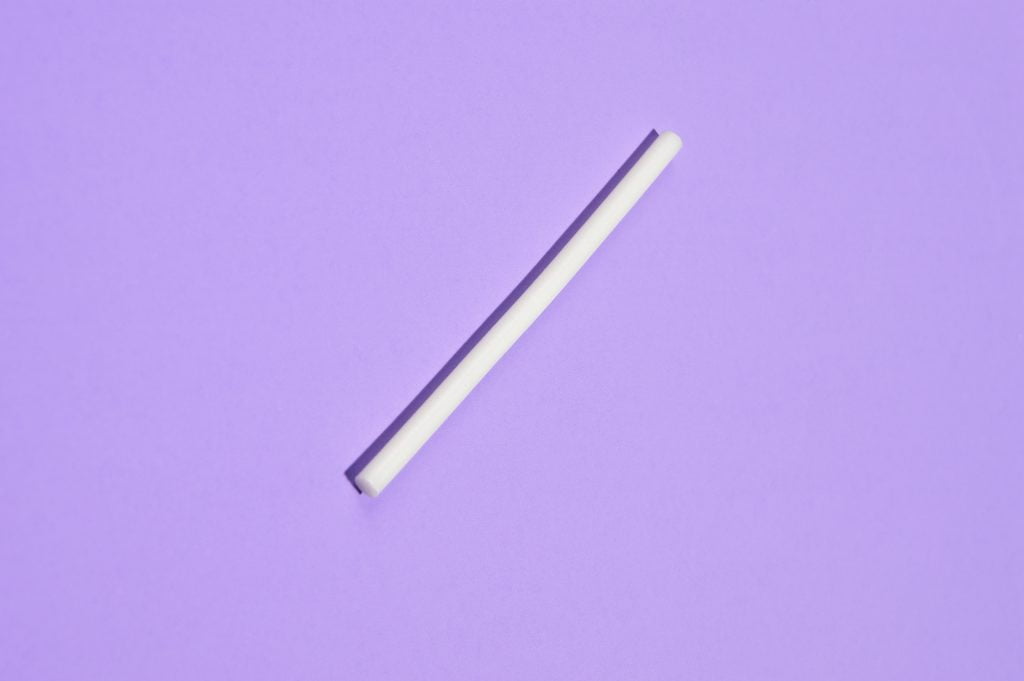 Image of an Nexplanon contraceptive implant on a purple background