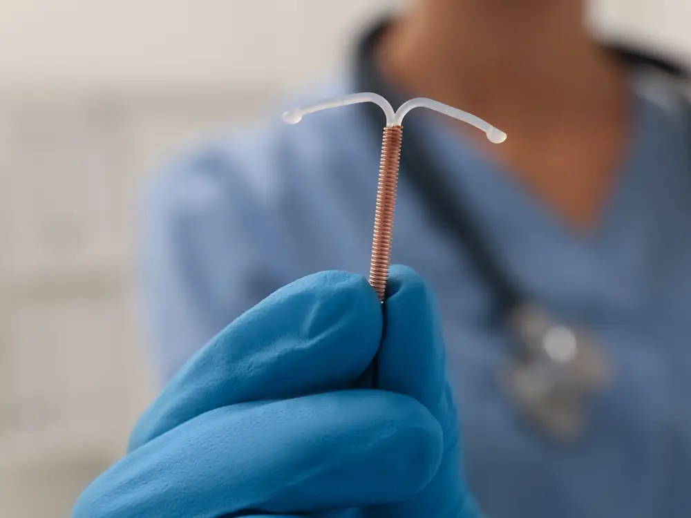 Doctor holding a copper contraceptive coil